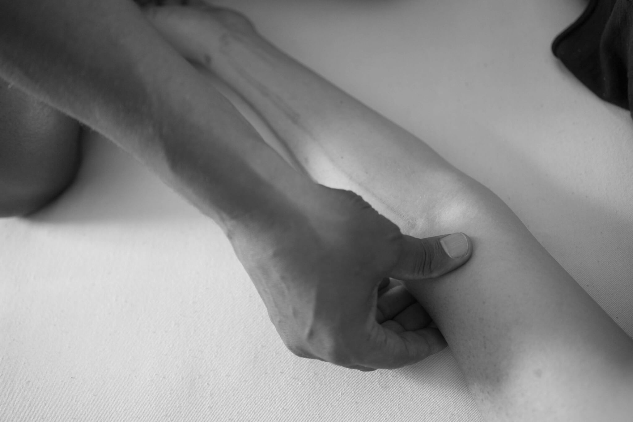 Black and white filtered shot of acupressure treatment for wrist pain