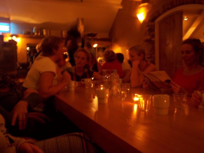 Ladies talking at their table with candle lights in a restaurant while some of them checking the menu